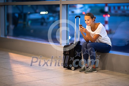 Young woman with her luggage at an international airport, before going through the check-in and the security check before her flight