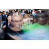 Crowd of people walking on city street - motion blurred image with unrecognizable faces - Young woman standing still, feeling down, depressed