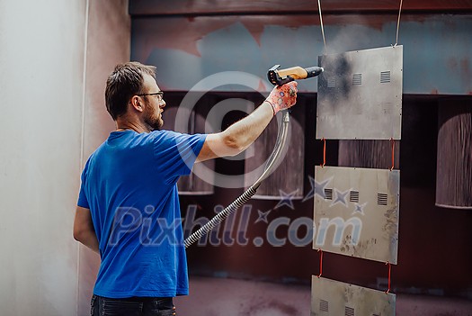 The painter paints the iron element. Industrial painting parts. Metal designs. High-quality photo The painter paints the iron element. Industrial painting parts. Metal designs. High-quality photo