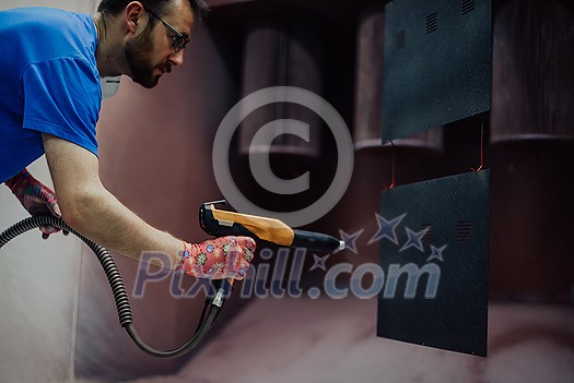 The painter paints the iron element. Industrial painting parts. Metal designs. High-quality photo The painter paints the iron element. Industrial painting parts. Metal designs. High-quality photo