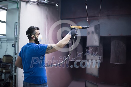 The painter paints the iron element. Industrial painting parts. Metal designs. High-quality photo The painter paints the iron element. Industrial painting parts. Metal designs. High-quality photo