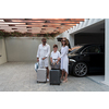 A photo of a modern family carrying suitcases from a garage to their luxury seaside home during a vacation. Vacation concept. Selective focus. High-quality photo
