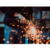 Heavy Industry Engineering Factory Interior with Industrial Worker Using Angle Grinder and Cutting a Metal Tube. Contractor in Safety Uniform and Hard Hat Manufacturing Metal Structures. High-quality photo