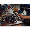 Industrial worker man soldering cables of manufacturing equipment in a factory. Selective focus. High-quality photo