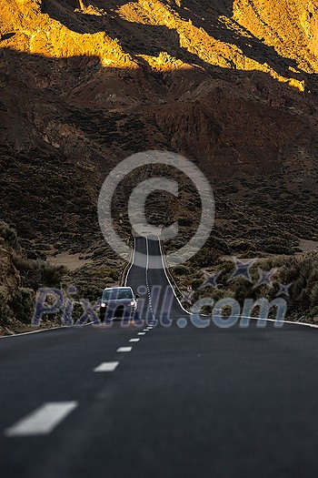 Long road in a mountain valley with a car on it - Teide National Park, Tenerife, Canary islands Long road in a mountain valley with a car on it - Teide National Park, Tenerife, Canary islands