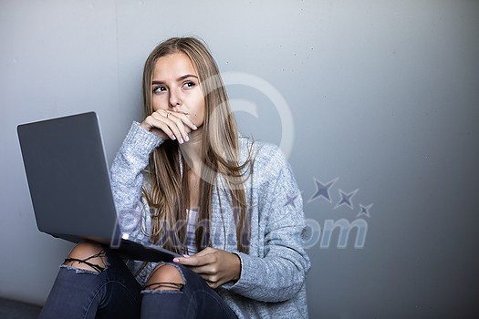 Pretty, young woman with her laptop studying for an exam/working