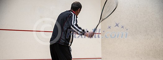 Squash player in action on a squash court (motion blurred image; color toned image) Squash player in action on a squash court (motion blurred image; color toned image)