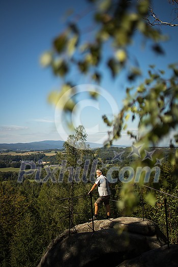 Senior man enjoying the outdoors, hiking, walking throught lovely nature