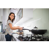 Pretty, young woman in her modern kitchen, by the fridge, about to cook a healthy meel for her family (color toned image)