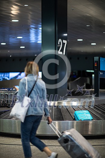 People at an international airport, at the baggage claim zone - motion blurred image