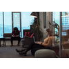 Two businesswomen sitting in a modern coworking space on a break from work and relaxing using a laptop. Selective focus. High-quality photo