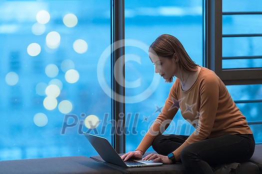 A young woman sitting in a modern space while working on a project on a laptop. Selective focus . High-quality photo A young woman sitting in a modern space while working on a project on a laptop. Selective focus . High-quality photo