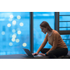 A young woman sitting in a modern space while working on a project on a laptop. Selective focus . High-quality photo