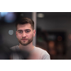 Portrait of happy millennial male business owner in modern office. Businessman, smiling and looking at camera. Leadership concept. Head shot. High-quality photo