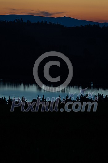 Dramatic scenic evening view, amazing scenery with dark mountain forest, lake and a lovely sunset sky. Dramatic scenic evening view, amazing scenery with dark mountain forest, lake and a lovely sunset sky.