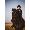 Female horse rider riding outdoors on her lovely horse