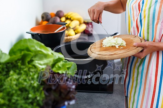 Young woman cooking in her modern kitchen (shallow DOF; color toned image)