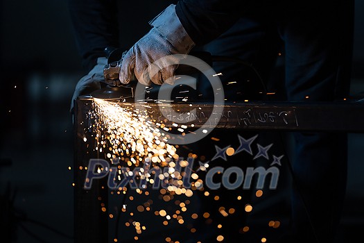 Man working on iron with grinder. Man at work. Sparkles and fire from grinder cutting. Grinder. Worker. Man working on iron with grinder. Man at work. Sparkles and fire from grinder cutting. Grinder. Worker.