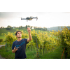 Young man flying a drone in warm evening sunlight