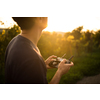 Young man flying a drone in warm evening sunlight