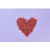 Dried red rose petals shaped as heart on toned background with copy space. Creative wedding invitation card design.