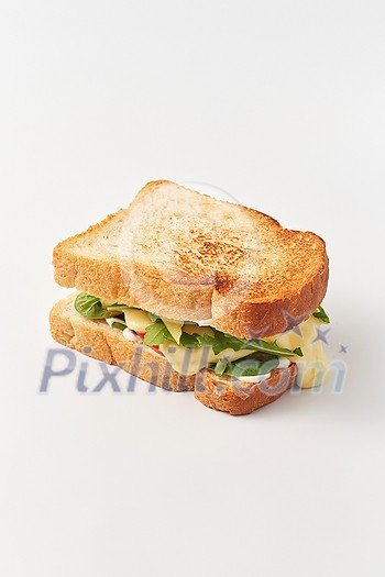 Simple composition of sandwich made of freshly toasted wheat bread slices and melted cheese with greens on white background