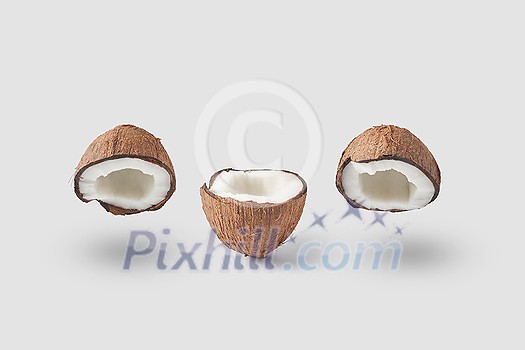 Set of natural coconut in halves with fresh ripe pulp and dry brown shell composed in row on white background casting shadows Set of natural coconut in halves with fresh ripe pulp and dry brown shell composed in row on white background casting shadows