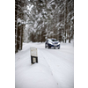 Car on a snowy winter road amid forests - using its four wheel drive capacities to get through the snow