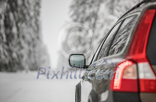 Car on a snowy winter road amid forests - using its four wheel drive capacities to get through the snow Car on a snowy winter road amid forests - using its four wheel drive capacities to get through the snow