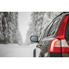 Car on a snowy winter road amid forests - using its four wheel drive capacities to get through the snow