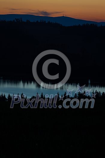 Dramatic scenic evening view, amazing scenery with dark mountain forest, lake and a lovely sunset sky. Dramatic scenic evening view, amazing scenery with dark mountain forest, lake and a lovely sunset sky.