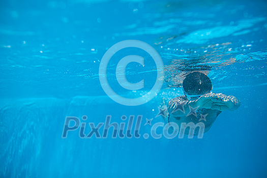Male swimmer swimming in an outdoor pool - keeping fit Male swimmer swimming in an outdoor pool - keeping fit