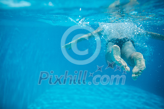 Male swimmer swimming in an outdoor pool - keeping fit Male swimmer swimming in an outdoor pool - keeping fit