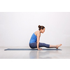 Woman doing Hatha asana Utpluti dandasana - lifted stuff pose on yoga mat on yoga mat in studio on grey bagckground