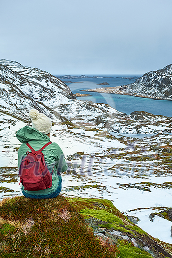 Woman tourist traveler enjoying a view of fjord in winter. Lofoten islands, Norway