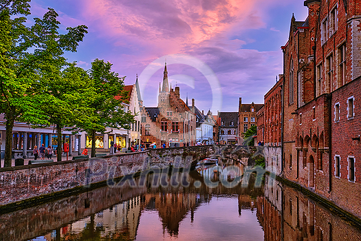 Evening dusk picturesque view of Bruges Brugge town canal with bridge and medieval houses, Belgium