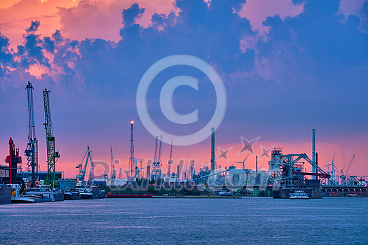 Port of Antwerp with harbor cranes in twilight and a ship passing under brigde Antwerp, Belgium