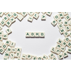 ADHD abbreviation formed of scrabble blocks over white background. Attention deficit hyperactivity disorder and mental health awareness.