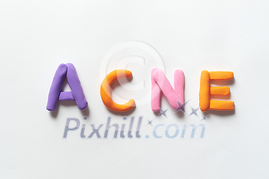 Acne word formed of vivid plasticine on white background. Skin disease and medical treatment concept.