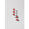 Red and white pharmaceutical pills laid over white background. Flat lay with copy space. Health care and medication-assisted treatment.