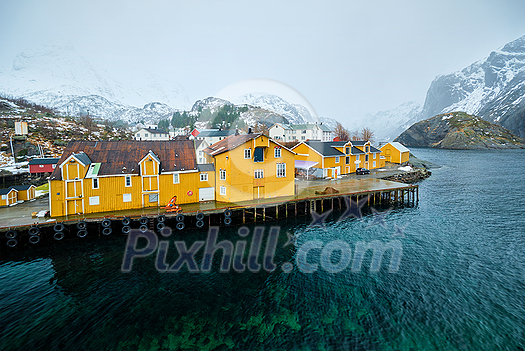 Panorama of Nusfjord authentic fishing village with yellow rorbu houses in Norwegian fjord in winter. Lofoten islands, Norway Panorama of Nusfjord authentic fishing village with yellow rorbu houses in Norwegian fjord in winter. Lofoten islands, Norway
