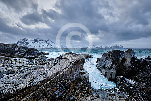 Waves of Norwegian sea crushing at rocky coast in fjord. Vikten, Lofoten islands, Norway Waves of Norwegian sea crushing at rocky coast in fjord. Vikten, Lofoten islands, Norway