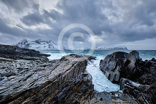 Waves of Norwegian sea crushing at rocky coast in fjord. Vikten, Lofoten islands, Norway