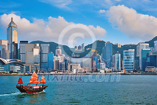Hong Kong skyline cityscape downtown skyscrapers over Victoria Harbour in the evening with junk tourist ferry boat on sunset with dramatic sky. Hong Kong, China Hong Kong skyline cityscape downtown skyscrapers over Victoria Harbour in the evening with junk tourist ferry boat on sunset with dramatic sky. Hong Kong, China