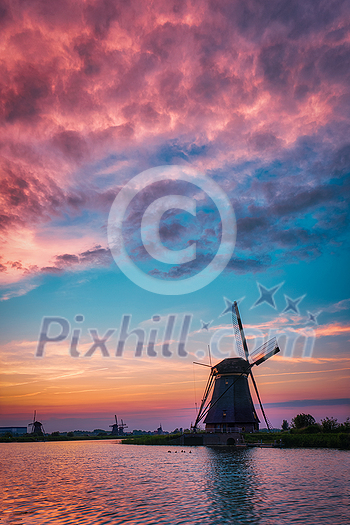 Netherlands rural landscape with windmills at famous tourist site Kinderdijk in Holland on sunset with dramatic sky