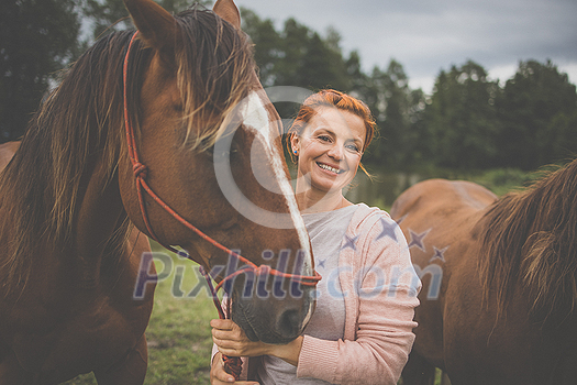 Pretty, young, redhead woman with her lovely horse, during her favorite leisure Pretty, young, redhead woman with her lovely horse, during her favorite leisure