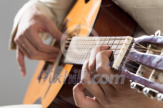 Close up of male hands playing acoustic guitar Close up of male hands playing acoustic guitar