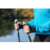 Nordic walking exercise adventure hiking concept - closeup of woman's hand holding nordic walking poles