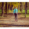 Vintage retro effect filtered hipster style image of nordic walking adventure and exercising concept - woman hiking with nordic walking poles in park