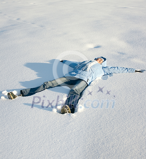 Happy young girl  lying in the snow
